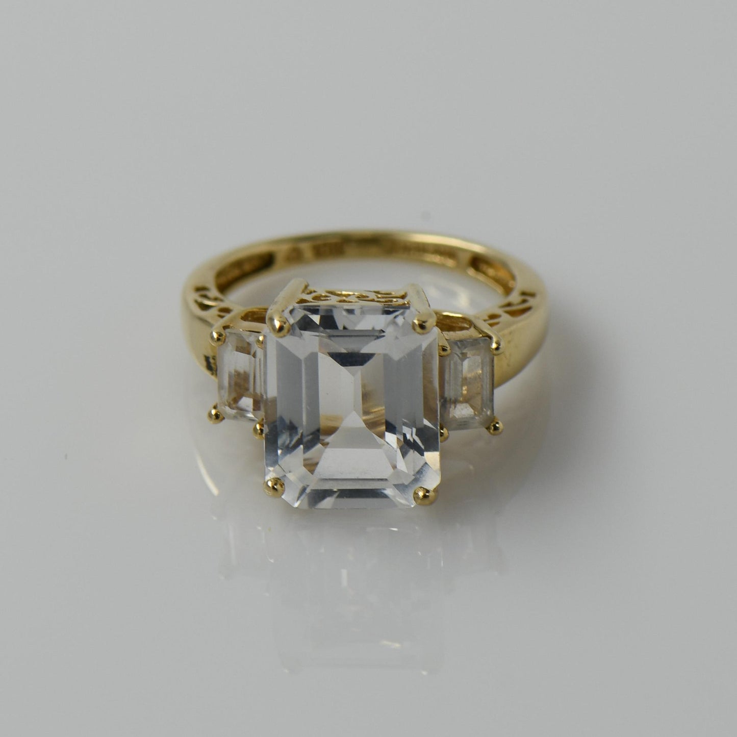 White Topaz Emerald Cut Three Stone 10k Yellow Gold Ring